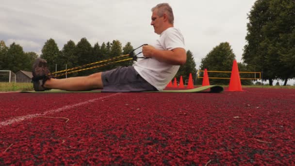 Man Gör Fitnessövningar Stadion — Stockvideo