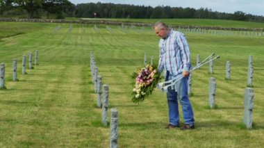 Engelli kıdemli mezarına çiçek çelenk koymak