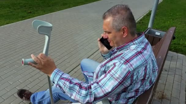 Funktionshindrade Sitter Bänken Och Använder Smart Telefon — Stockvideo
