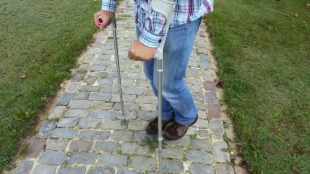 Man Crutches Cobbled Path — Stock Video