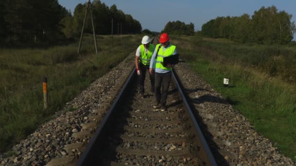 鉄道エンジニアがアシスタントの鉄道レールをチェックします — ストック動画