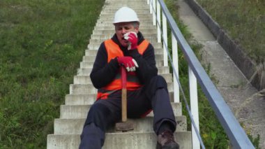 Tembel işçi çekiç ile rahatla beton merdivende