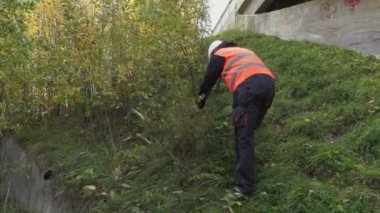 Çalılar yakınındaki açık havada, balta kullanarak alt