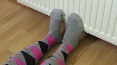 Renkli kadında tutma sürümek radyatör Isıtma yakınındaki çorap