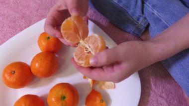 Kız mandalina dilimleri birbirinden ayırır