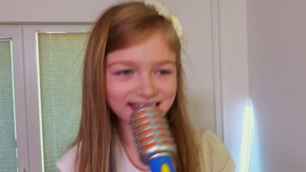 Lachende Meisje Met Een Speelgoed Microfoon Zingt — Stockvideo