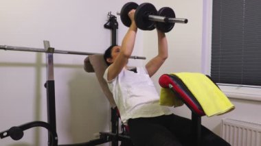 Kadın spor salonu bankta dumbbells itmek