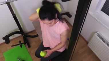 Kadın egzersiz yaptıktan sonra havlu kullanarak spor salonu bankta
