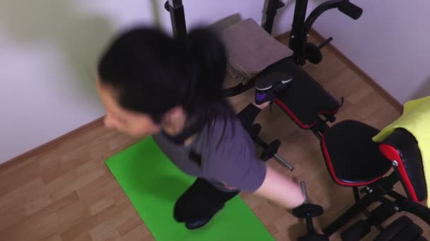 在健身房长椅上做单腿仰卧起坐的妇女 — 图库视频影像