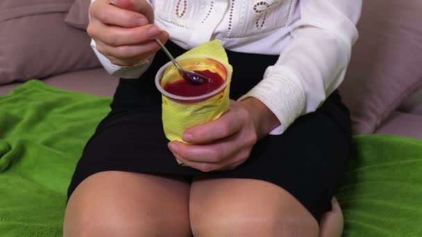 Frau Sitzt Auf Sofa Und Isst Joghurt — Stockvideo