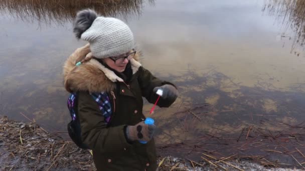 湖の近くのシャボン玉を吹く少女 — ストック動画