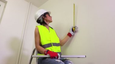 Mezura kullanarak inşaat işçisi kadın