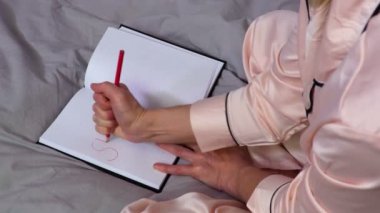 Kadın defter üzerinde kırmızıyla stres sözcüğü yazmaya