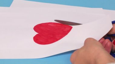 Beyaz kağıt üzerine kırmızı kalp şeklinde kesip kadın