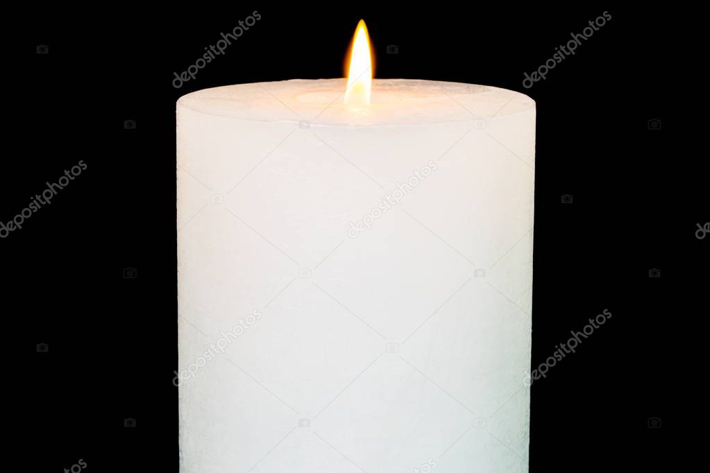 White burning candle on black