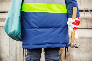 Beton blokların yanında çekiçile kadın müfettiş