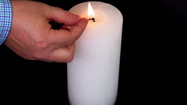 Человек Зажигает Белую Свечу Черном — стоковое видео