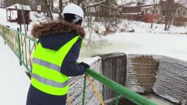 Mutlu kadın mühendis Köprüsü'nde savaklar yakınındaki başparmak sırıtmak