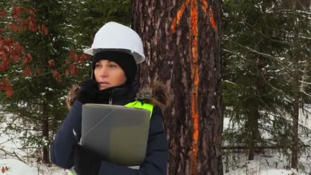 マーク付きの木の近くのスマート フォンを使用して女性の林業労働者 — ストック動画
