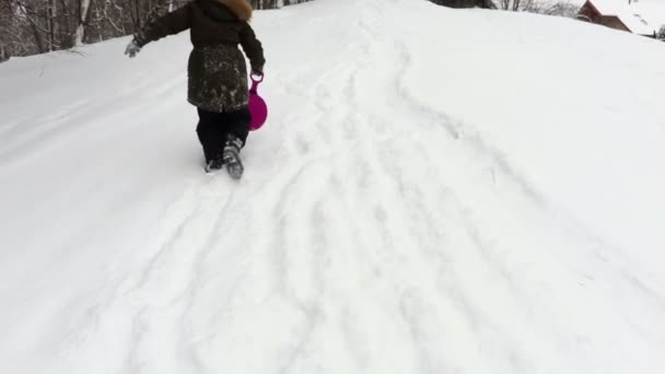 Happy Girl Toboggan Stepping Snow Covered Hill — Stock Video