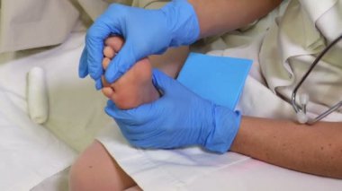 Kadın Doktor hastanın bacak yaralanmasını inceliyor