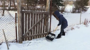 Bahçe kapıları yakın kar kürek kullanan kadın