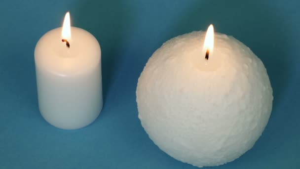 Twee Witte Brandende Kaarsen Blauwe Achtergrond Bovenaanzicht — Stockvideo