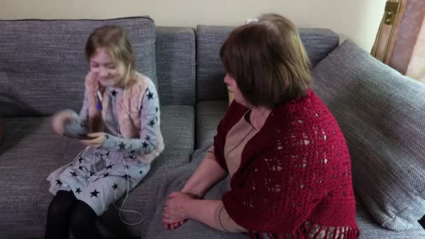孫娘と一緒に音楽を聴く祖母 — ストック動画