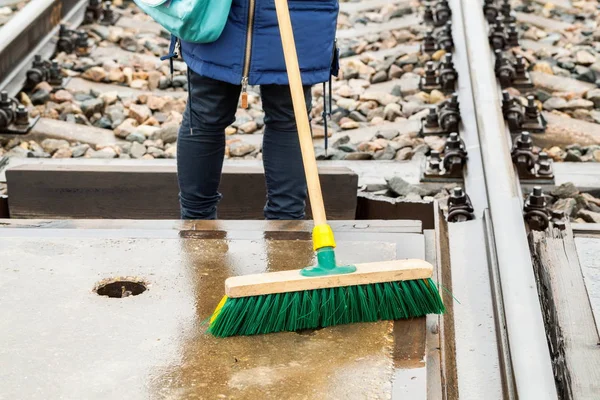 Female Railway Employee Clean Brush Railway Crossing Close — Stock Photo, Image