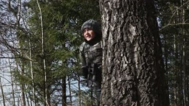 Ağaç arkasında dürbün ile kadın