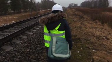 Kadın demiryolu işçisi demiryolu durumunu inceliyor.
