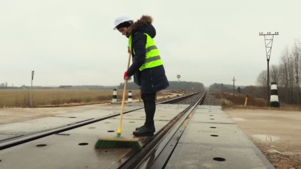 冬の女性鉄道労働者クリーン鉄道横断歩道 — ストック動画