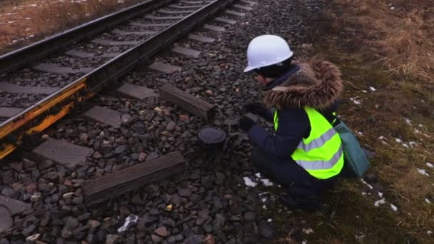 女性鉄道技術者が鉄道技術設備の写真を撮る — ストック動画