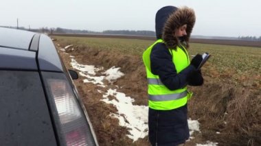 Tarlada arabanın yanında yazan kadın çiftçi