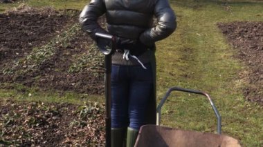  Çatal ve el arabası yakın sırt ağrısı ile kadın bahçıvan