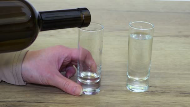 震える手を持つ女性がショットグラスにアルコールを注ぐ — ストック動画