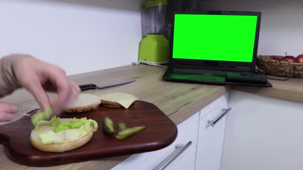 Vrouw Maken Hamburger Kijken Laptop Groen Scherm — Stockvideo