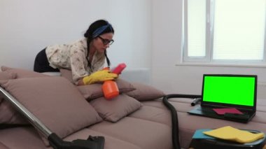 Yeşil ekran ile koltuk izlerken laptop yakın kadın temizleyici