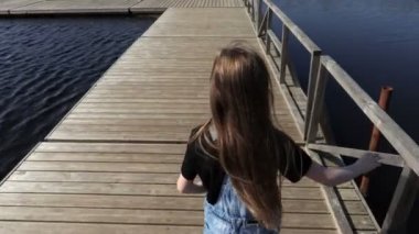 Gölde yüzen köprüde yürüyen küçük kız