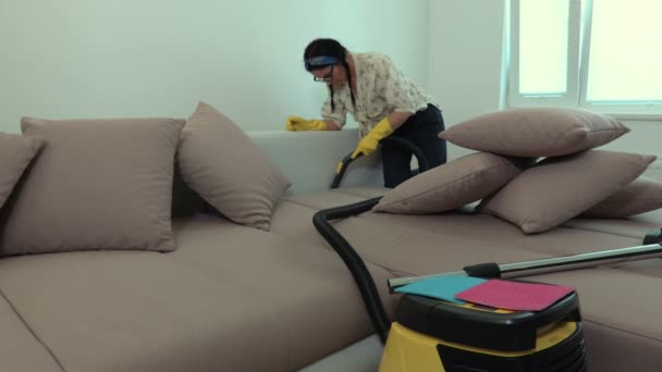 掃除機でソファを掃除し 掃除機の圧力をチェックする女性 — ストック動画