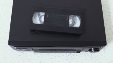 Kadın Vhs kasetini VCR oynatıcısına koydu.