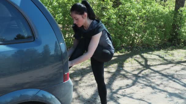 Fitness Kobieta Wiąże Sznurowadła Pobliżu Samochodu Przed Bieganiem Torze — Wideo stockowe
