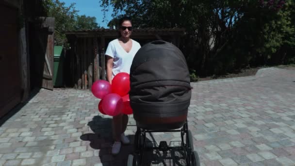 Kvinna Med Färgglada Ballonger Och Barnvagnen — Stockvideo
