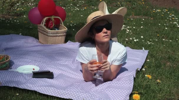 Kobieta Leżąca Kocu Piknikowym Pijąca — Wideo stockowe