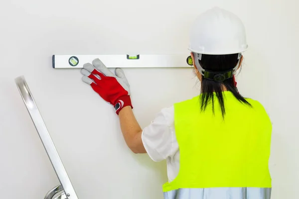 壁のレベルをチェックする女性建設労働者 — ストック写真
