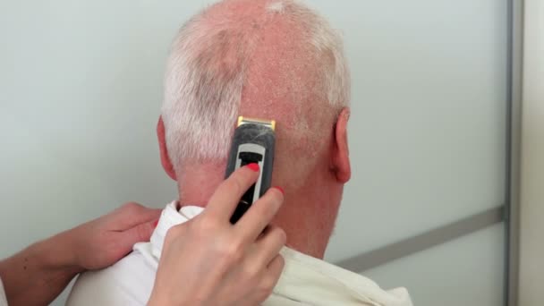 刺激性の皮膚を持つ男性にクリッパーで髪を切断する女性の床屋 — ストック動画