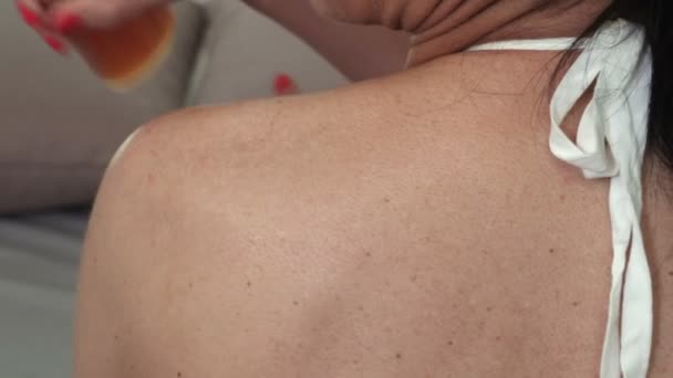 肩にセルフ日焼けローションを塗る女性クローズアップ — ストック動画