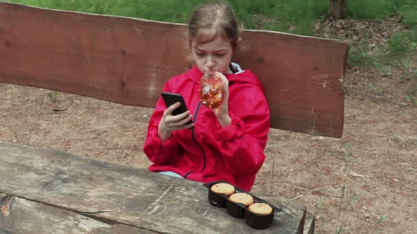 Маленька Дівчинка Використовує Смартфон Безалкогольний Напій — стокове відео