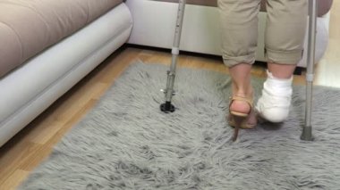 Yüksek topuklu ve koltuk değnekleriyle yaralı bir kadın.