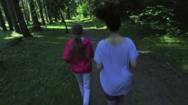 Kadın ve kız parkta koşuşturuyor.
